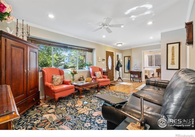 living room featuring light wood-type flooring, ceiling fan, and crown molding