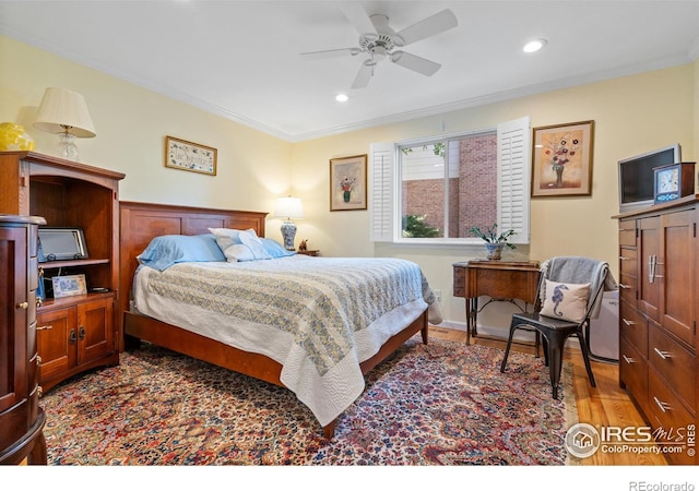 bedroom featuring ceiling fan, ornamental molding, and wood-type flooring