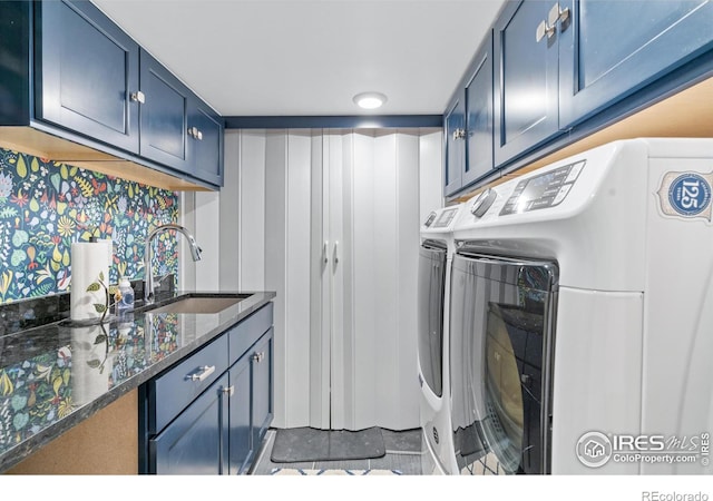 laundry room featuring cabinets, sink, and washer and clothes dryer