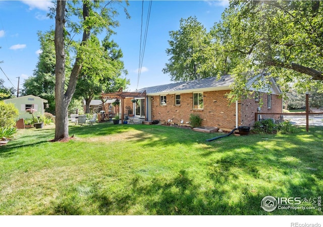 rear view of property with a pergola and a yard