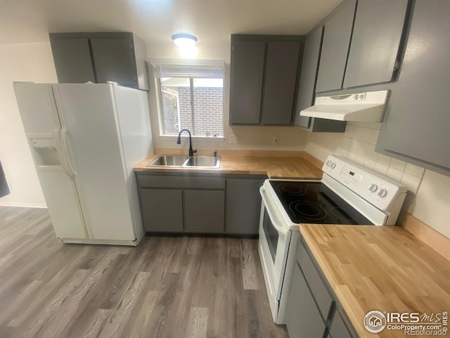 kitchen with gray cabinets, sink, wooden counters, dark hardwood / wood-style flooring, and white appliances