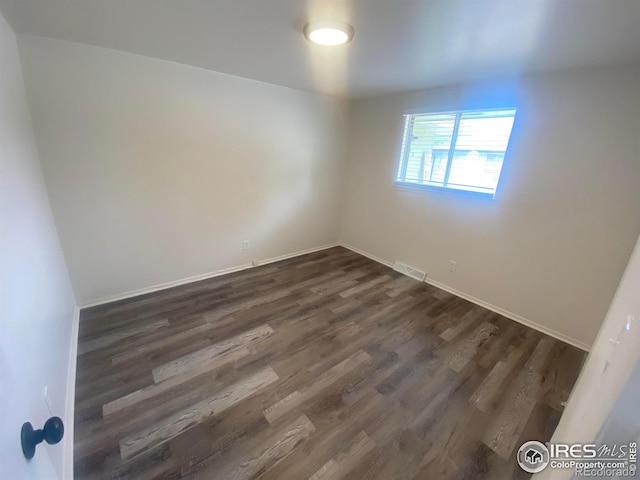 empty room featuring dark hardwood / wood-style flooring