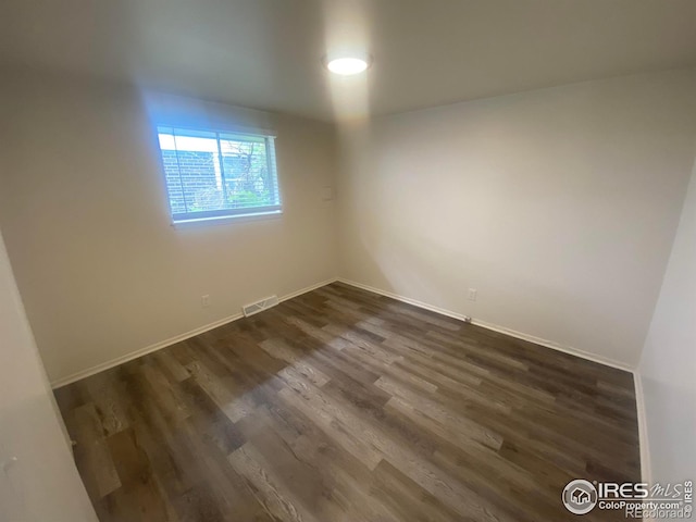 empty room with dark wood-type flooring