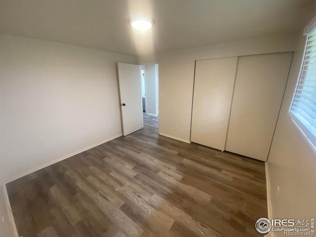 unfurnished bedroom featuring wood-type flooring and a closet