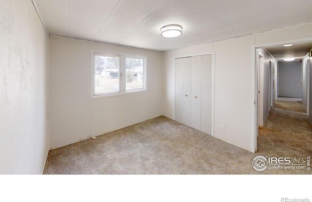 unfurnished bedroom with a textured ceiling, a closet, and carpet