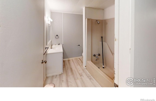 bathroom with  shower combination, vanity, toilet, and wood finished floors
