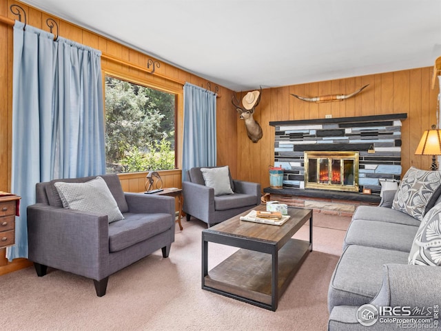 carpeted living room featuring a fireplace and wooden walls