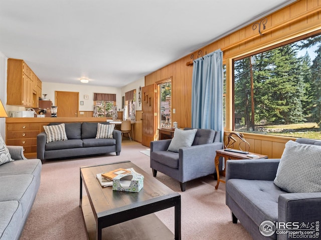 carpeted living room featuring wooden walls