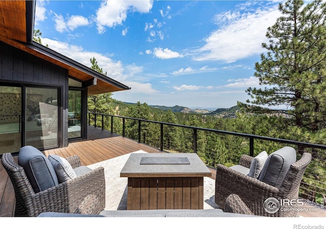 wooden terrace with an outdoor living space and a mountain view