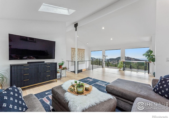 living room featuring lofted ceiling with skylight and light hardwood / wood-style flooring