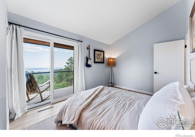 bedroom with access to exterior, light hardwood / wood-style flooring, and lofted ceiling