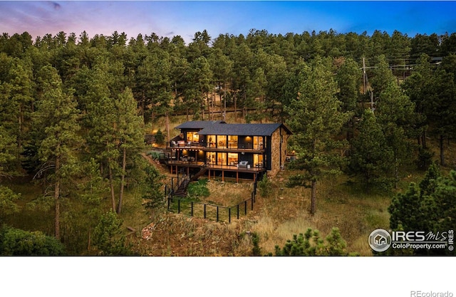 back house at dusk featuring a deck