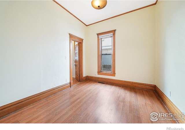 empty room featuring hardwood / wood-style flooring and crown molding