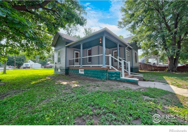 view of front of home featuring covered porch and a front lawn