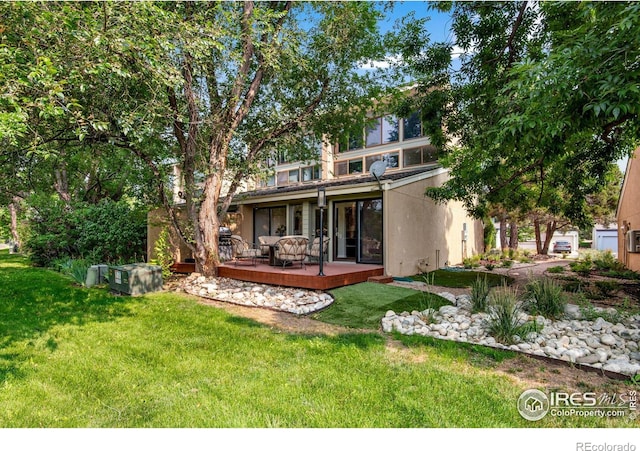 back of house featuring a deck and a yard