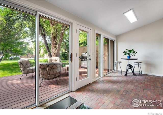 doorway to outside featuring vaulted ceiling