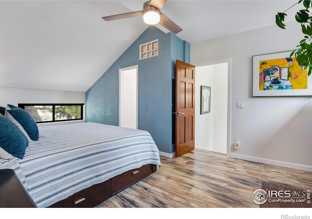 bedroom with ceiling fan, lofted ceiling, and wood-type flooring