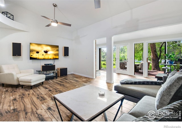 living room with hardwood / wood-style flooring, high vaulted ceiling, and ceiling fan