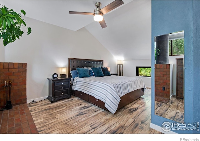 bedroom with ceiling fan, high vaulted ceiling, and hardwood / wood-style flooring