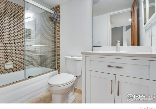 full bathroom featuring vanity, toilet, bath / shower combo with glass door, and tile patterned flooring