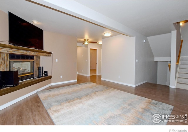 unfurnished living room with a multi sided fireplace, hardwood / wood-style flooring, and ceiling fan