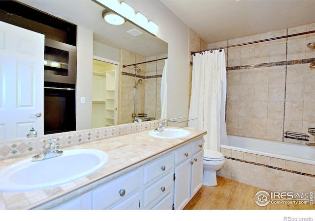 full bathroom with wood-type flooring, vanity, toilet, and shower / bath combination with curtain