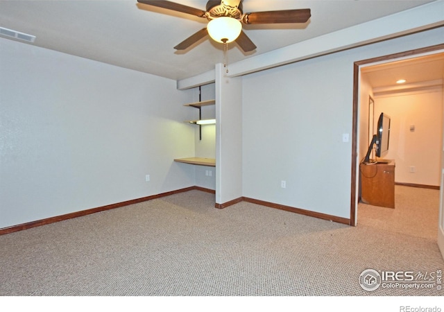 carpeted spare room with ceiling fan