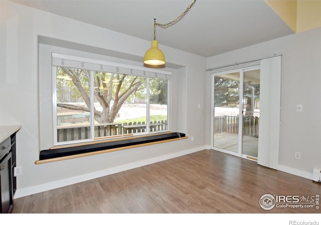 unfurnished dining area featuring wood-type flooring