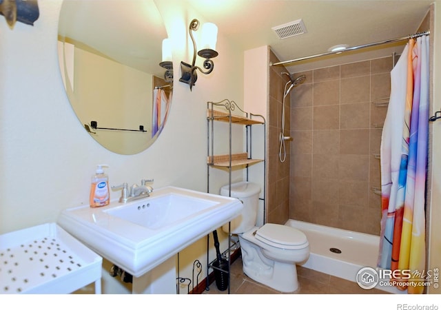 bathroom with walk in shower, tile patterned flooring, and toilet