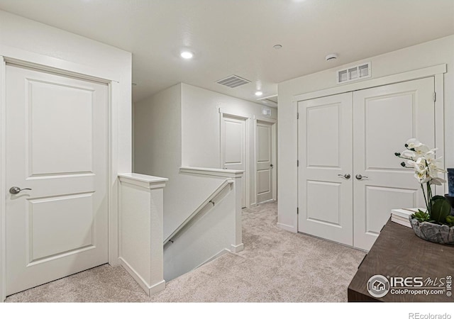 hallway with light colored carpet