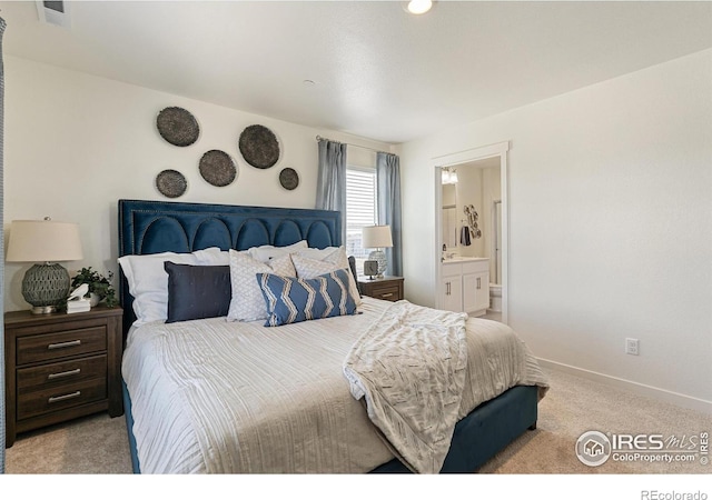 carpeted bedroom featuring ensuite bath