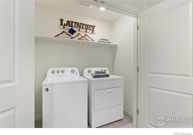 clothes washing area with separate washer and dryer and light tile patterned floors