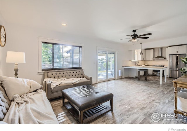 living room featuring a healthy amount of sunlight, light wood-style flooring, ceiling fan, and recessed lighting