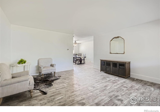 sitting room with baseboards and wood finished floors