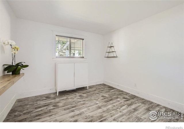 empty room with baseboards and wood finished floors