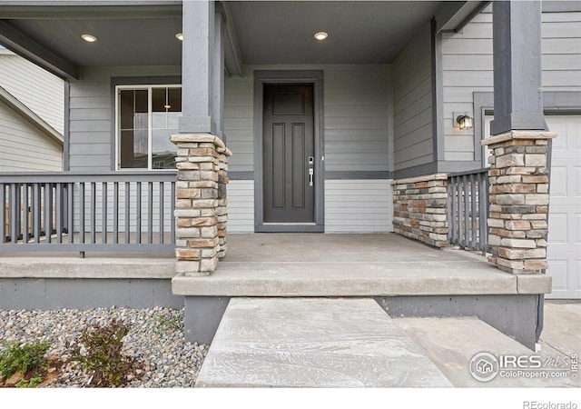 entrance to property featuring covered porch and stone siding