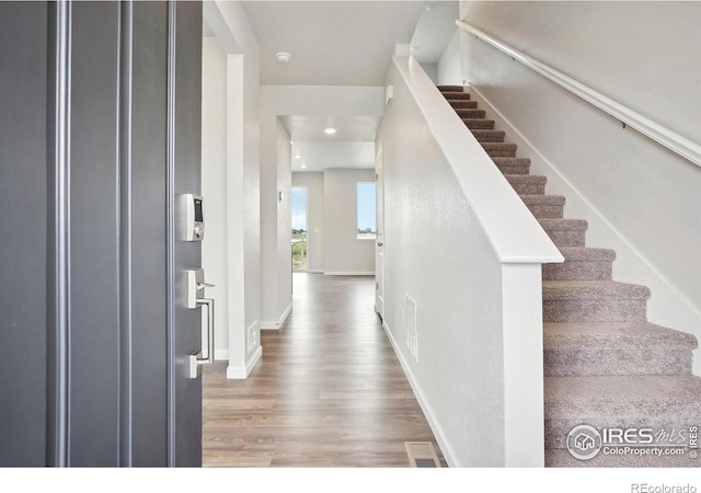 foyer featuring stairway, baseboards, and wood finished floors