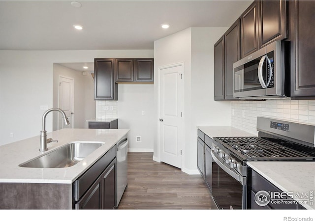 kitchen featuring dark brown cabinetry, appliances with stainless steel finishes, a sink, and wood finished floors