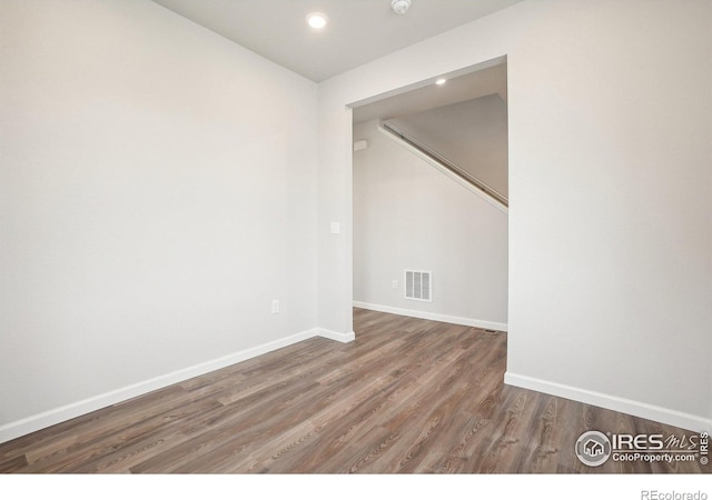 empty room with recessed lighting, visible vents, baseboards, and wood finished floors