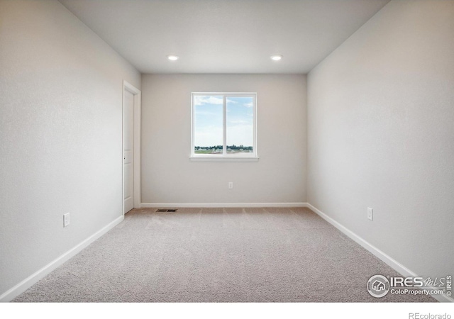 carpeted empty room with baseboards and recessed lighting