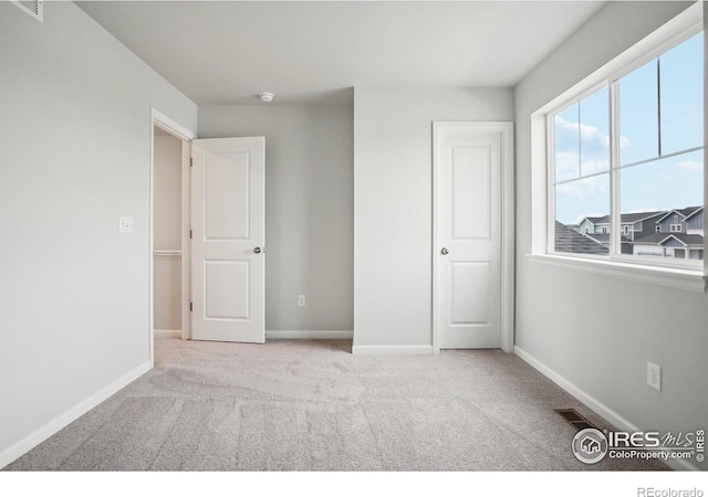 unfurnished bedroom with visible vents, baseboards, and carpet flooring