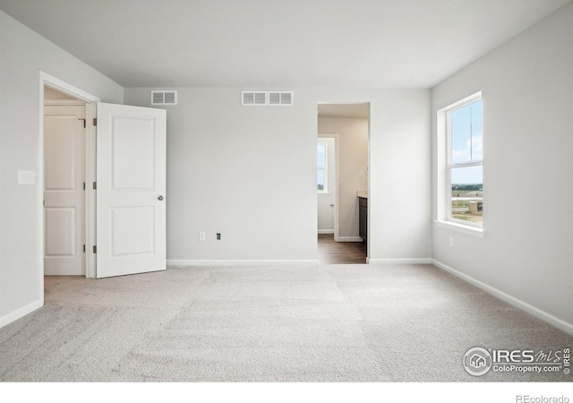 unfurnished bedroom featuring carpet floors, visible vents, and baseboards