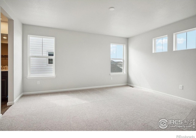 unfurnished room featuring baseboards and carpet flooring