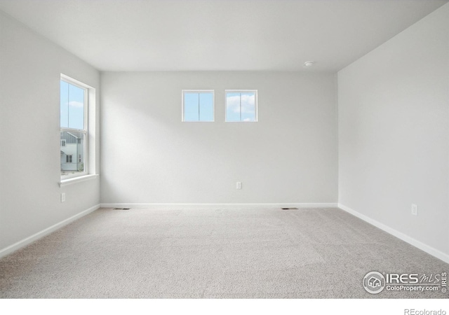 carpeted empty room with baseboards