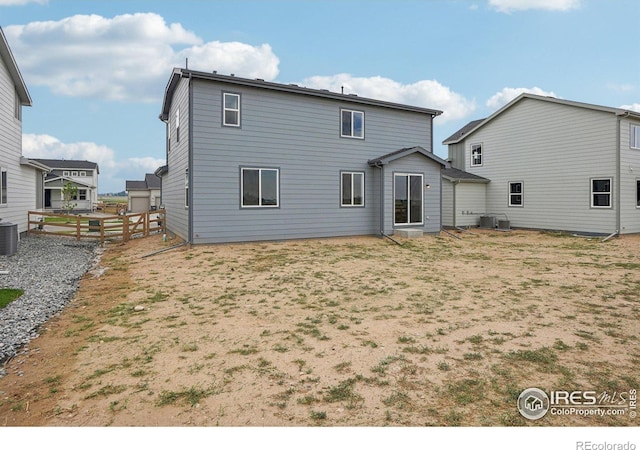 back of house with central AC and fence