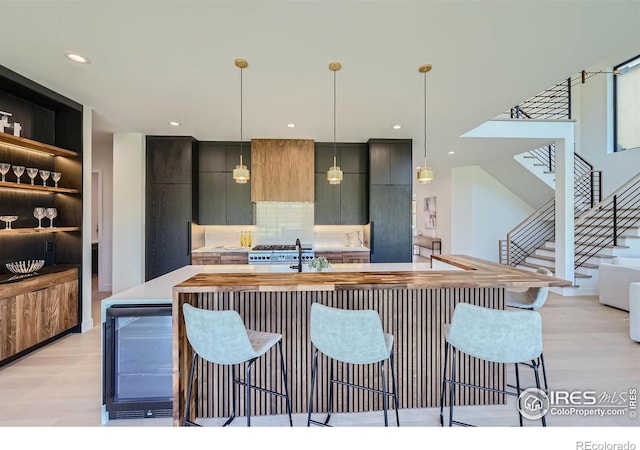 kitchen with hanging light fixtures, light hardwood / wood-style flooring, and a kitchen bar