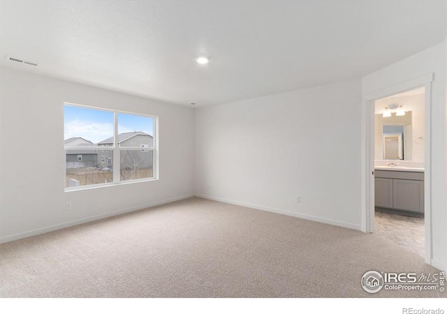 unfurnished bedroom with light colored carpet and ensuite bath