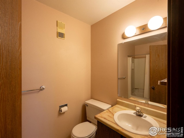 full bathroom featuring visible vents, a shower, vanity, and toilet