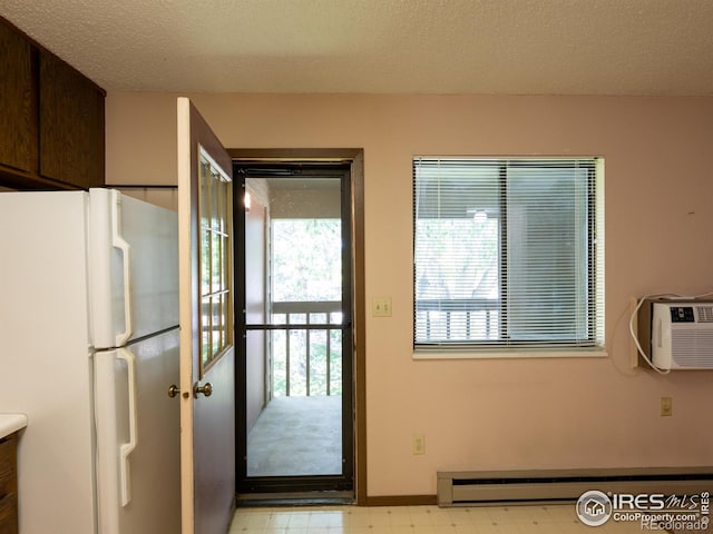 doorway to outside with baseboards, a wall mounted air conditioner, a textured ceiling, light floors, and a baseboard heating unit