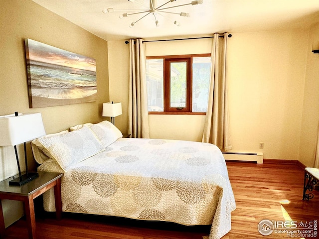 bedroom featuring hardwood / wood-style floors and a baseboard radiator